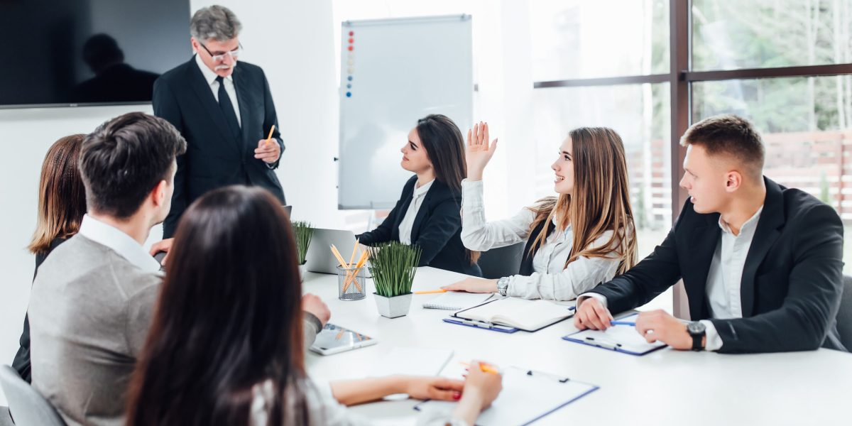 Boss  businessman holding papers hands and smiling.Young team of coworkers making great business discussion in modern coworking office.