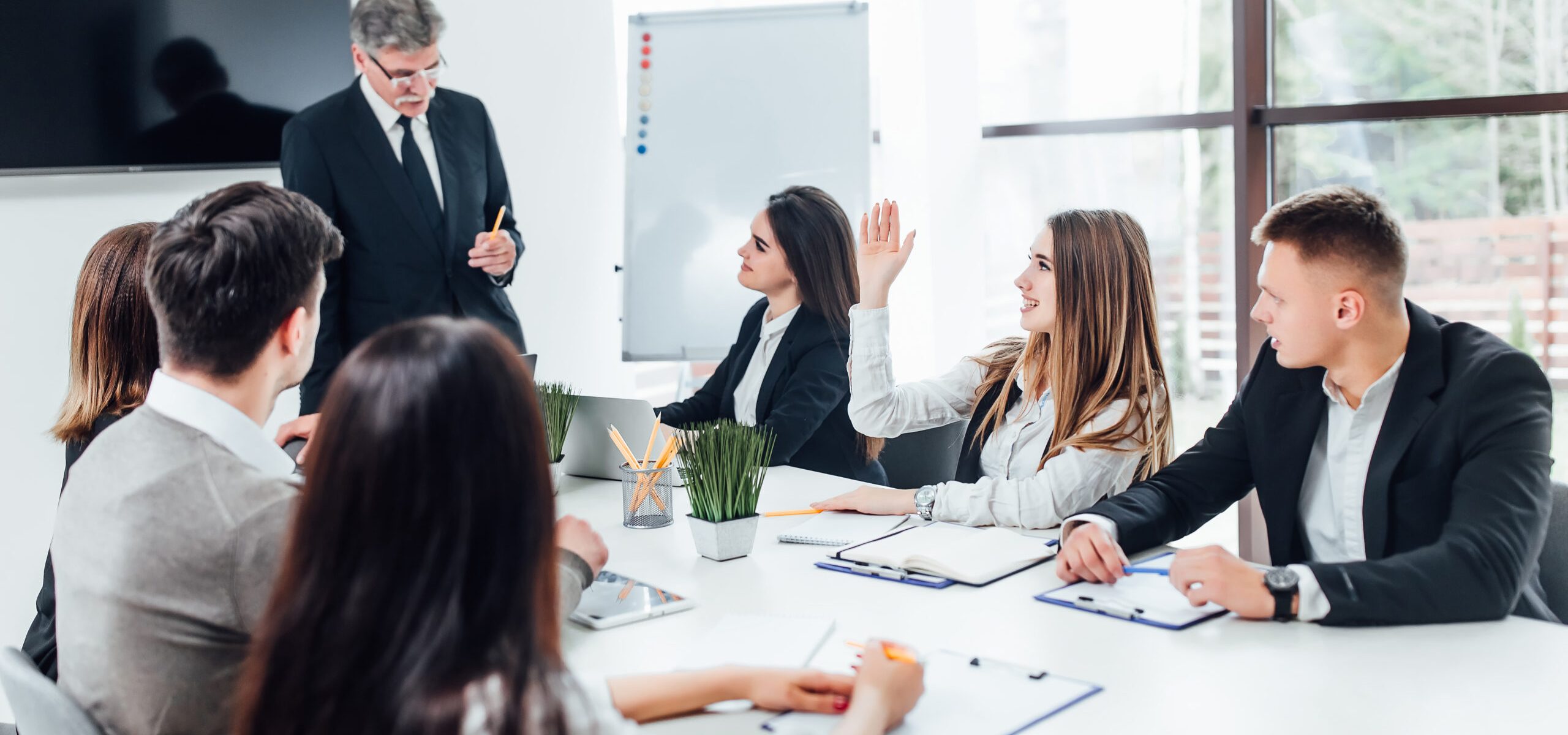 Boss  businessman holding papers hands and smiling.Young team of coworkers making great business discussion in modern coworking office.