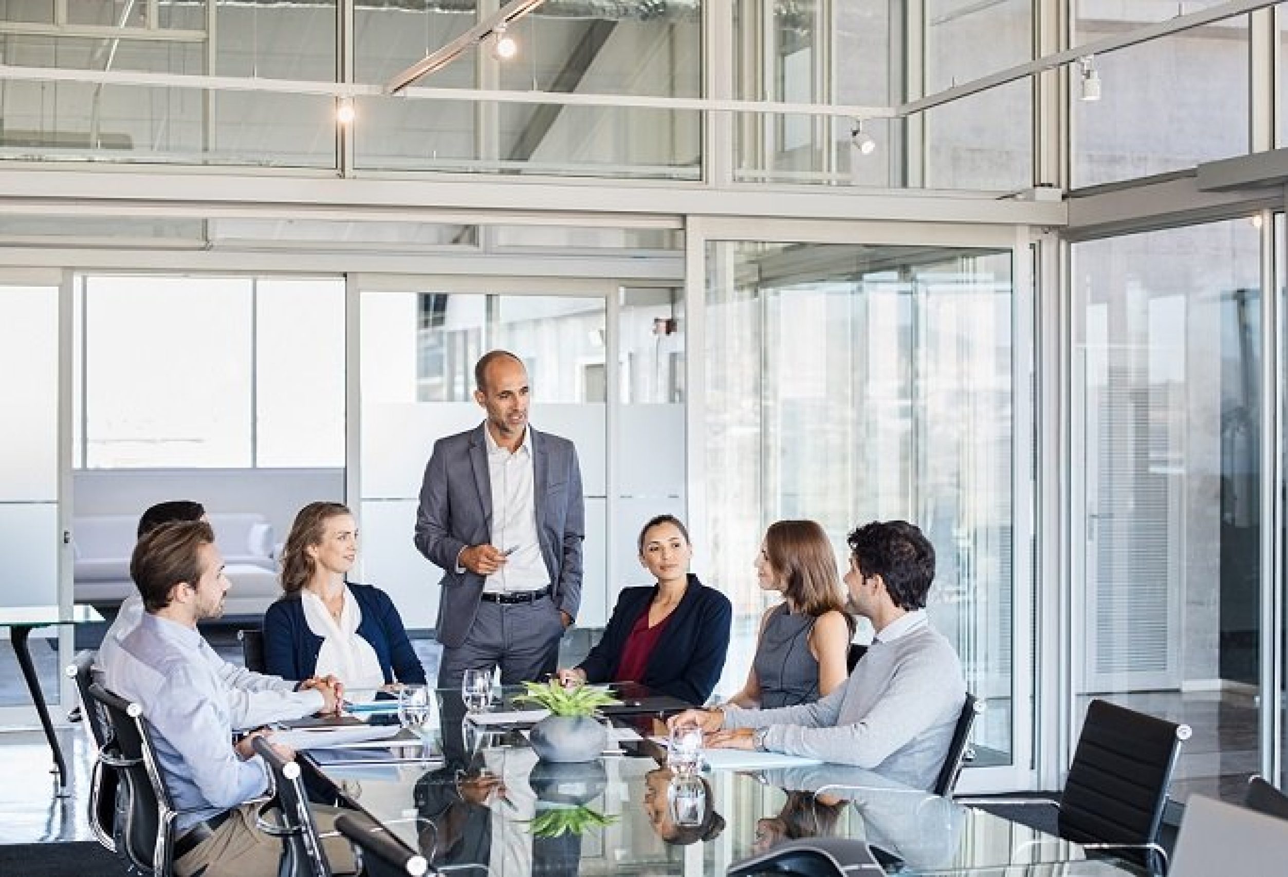 Human resource manager training people about company and future prospects. Group of businesspeople sitting in meeting room and listening to the speaker. Leader man training his work group in a conference room.